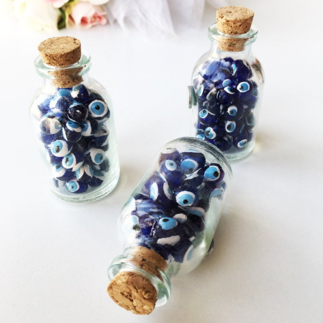 A collection of evil eye bottle magnets featuring glass bottles filled with colorful evil eye beads, perfect for home and office decor.