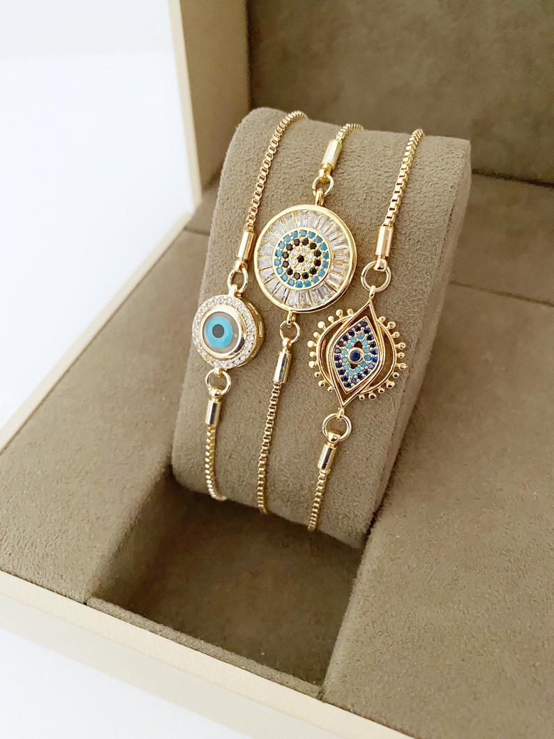 A beautiful adjustable Evil Eye Bracelet featuring a blue evil eye charm and sparkling cubic zirconia stones, crafted from tarnish-resistant stainless steel.