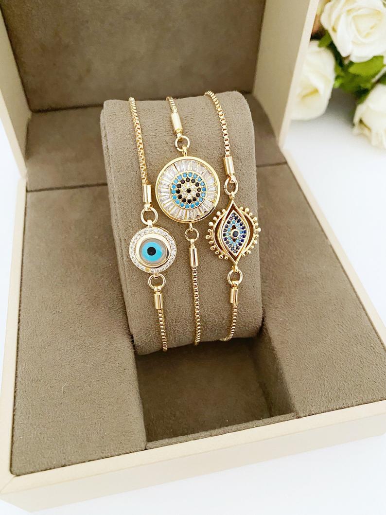 A beautiful adjustable Evil Eye Bracelet featuring a blue evil eye charm and sparkling cubic zirconia stones, crafted from tarnish-resistant stainless steel.