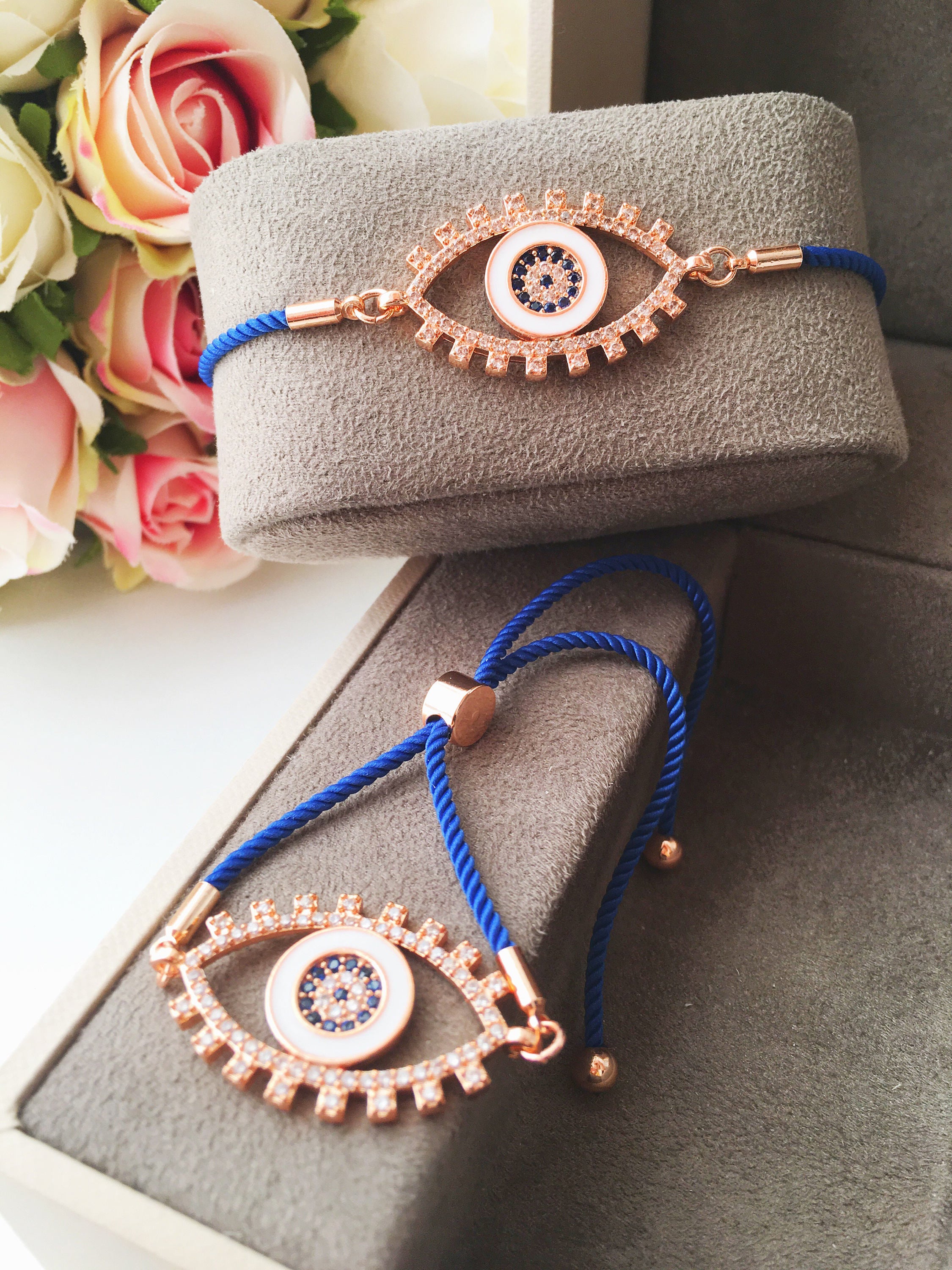 Handmade Evil Eye Bracelet with blue string and zirconia charm, featuring adjustable design and rose gold accents.