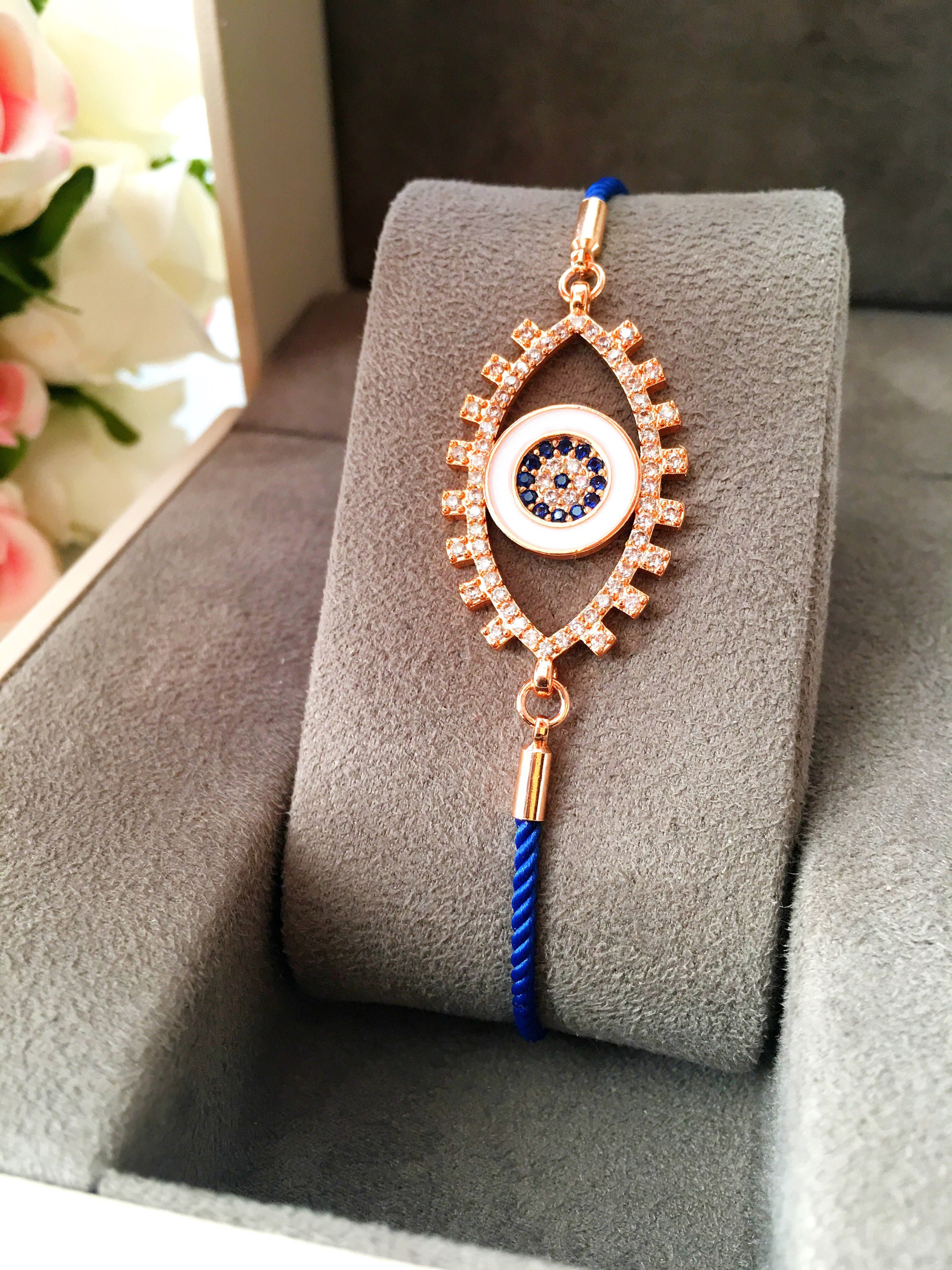 Handmade Evil Eye Bracelet with blue string and zirconia charm, featuring adjustable design and rose gold accents.