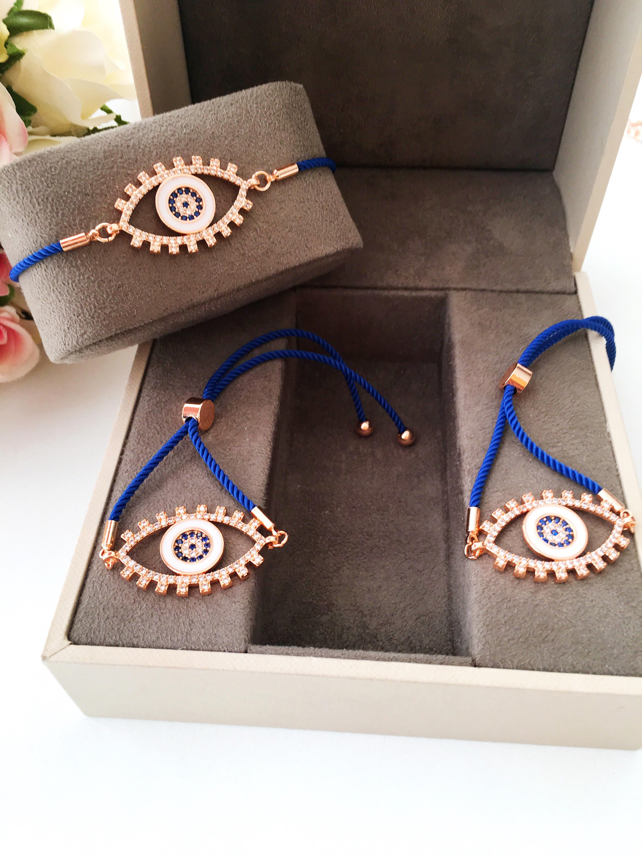 Handmade Evil Eye Bracelet with blue string and zirconia charm, featuring adjustable design and rose gold accents.