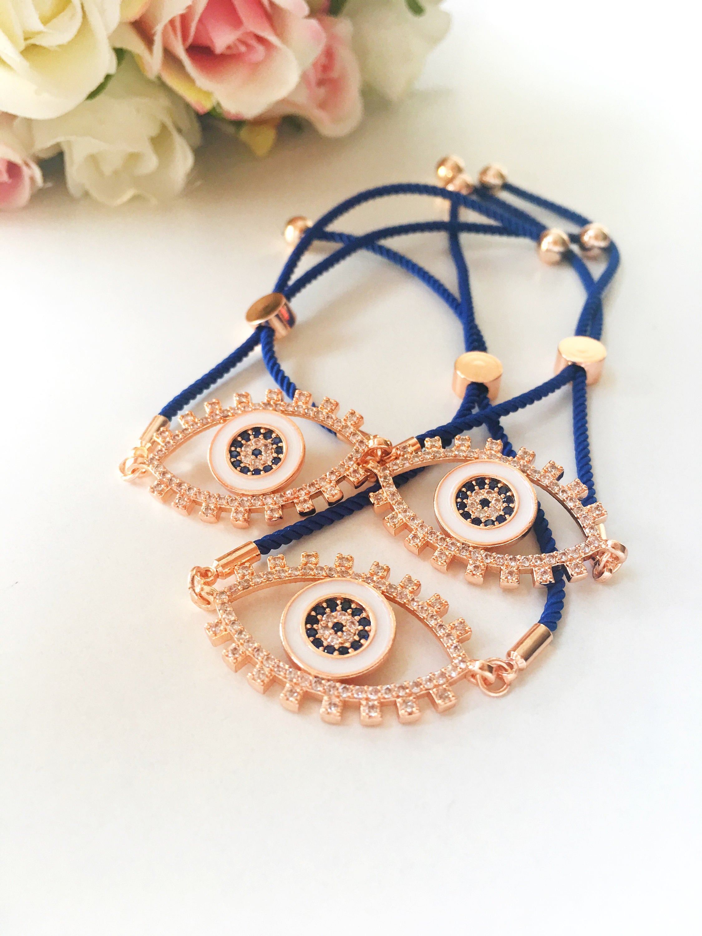 Handmade Evil Eye Bracelet with blue string and zirconia charm, featuring adjustable design and rose gold accents.