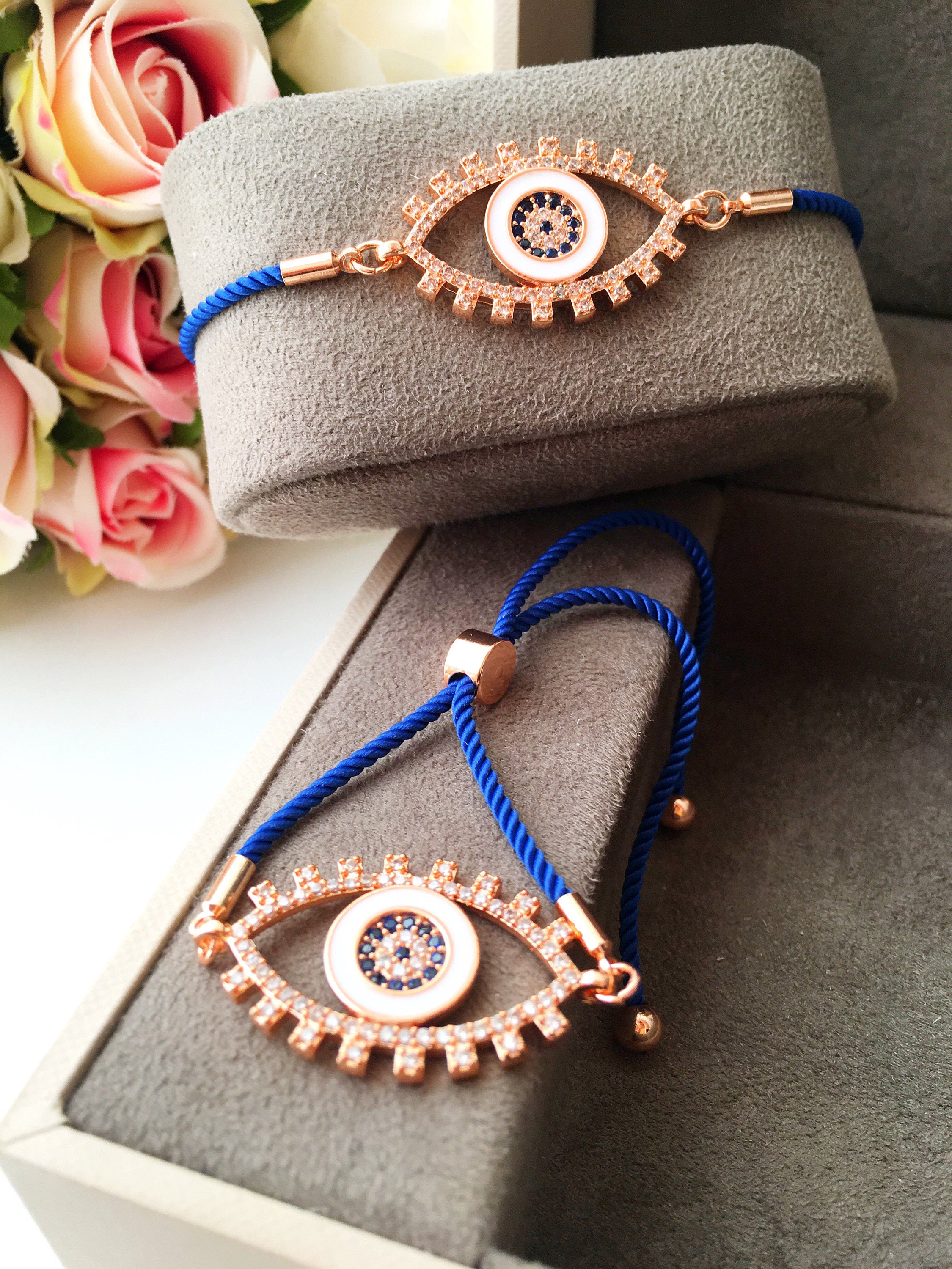 Handmade Evil Eye Bracelet with blue string and zirconia charm, featuring adjustable design and rose gold accents.