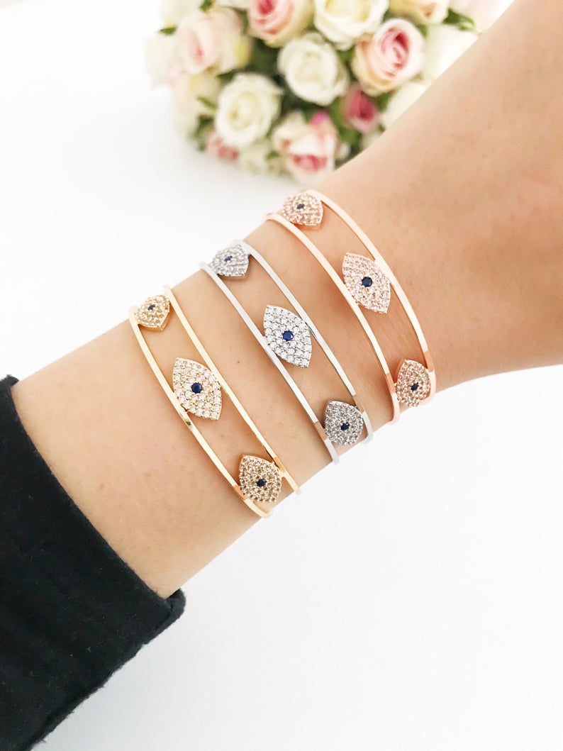 Elegant Evil Eye Bracelet in rose gold, featuring a movable oval charm and round bangle design, made from tarnish-resistant stainless steel.