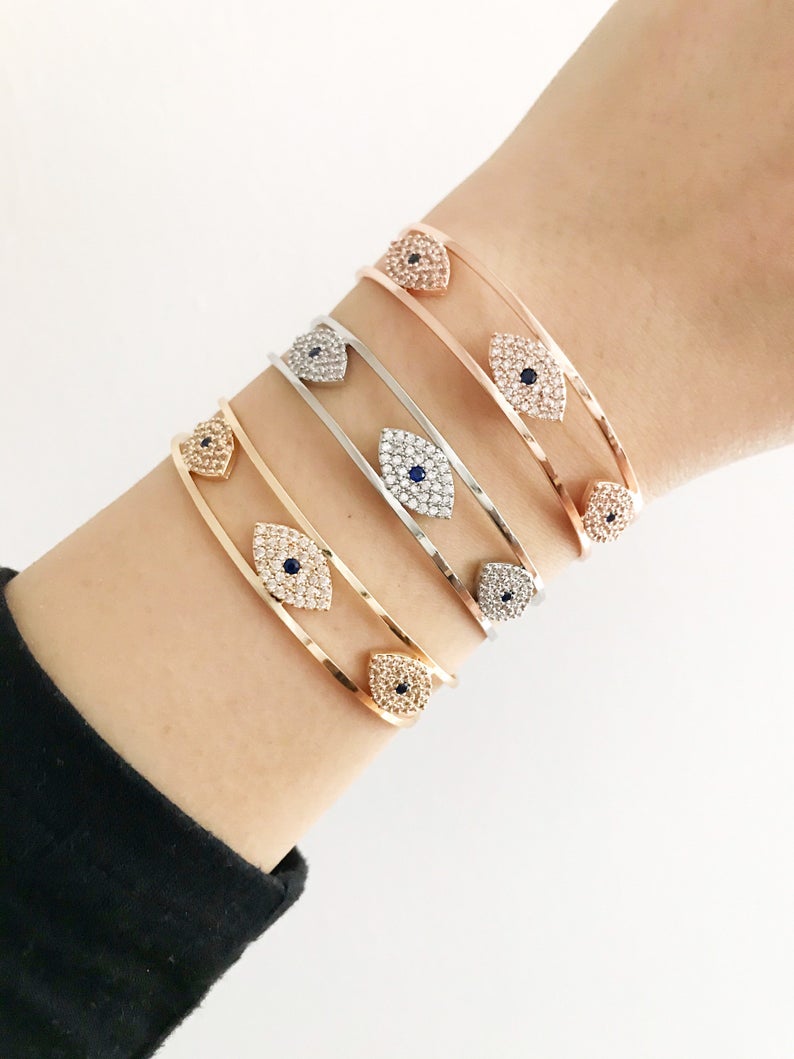 Elegant Evil Eye Bracelet in rose gold, featuring a movable oval charm and round bangle design, made from tarnish-resistant stainless steel.