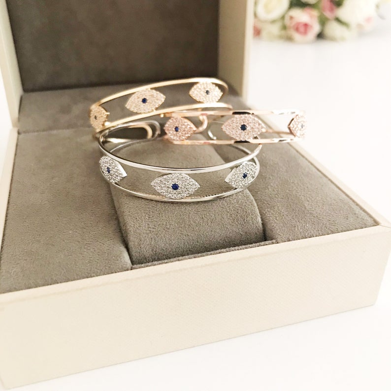 Elegant Evil Eye Bracelet in rose gold, featuring a movable oval charm and round bangle design, made from tarnish-resistant stainless steel.