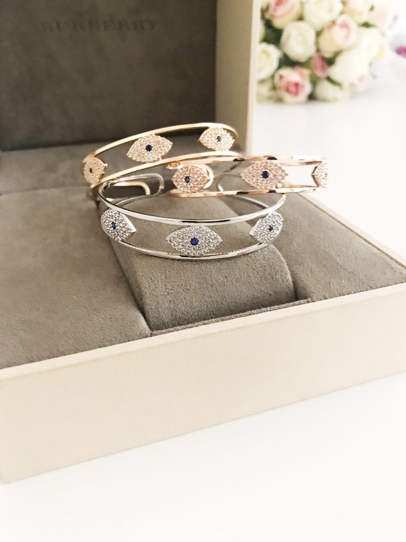 Elegant Evil Eye Bracelet in rose gold, featuring a movable oval charm and round bangle design, made from tarnish-resistant stainless steel.