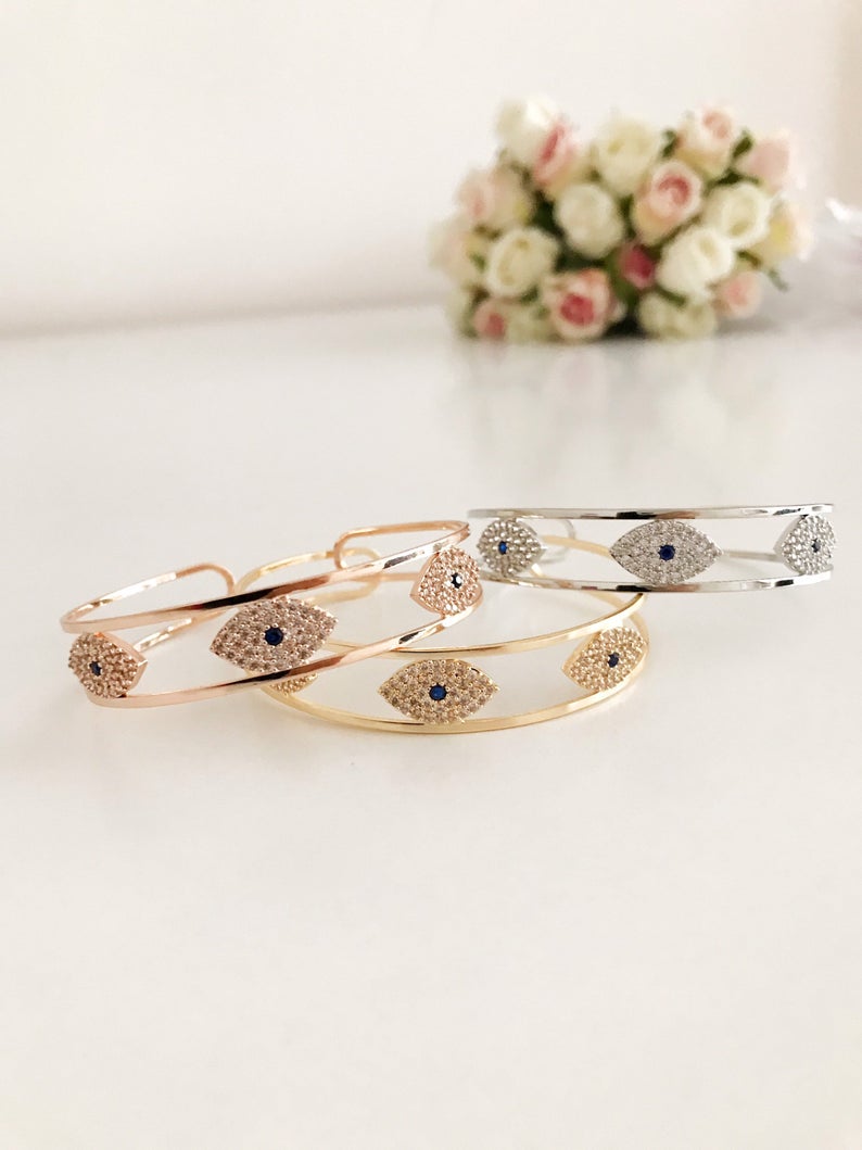 Elegant Evil Eye Bracelet in rose gold, featuring a movable oval charm and round bangle design, made from tarnish-resistant stainless steel.