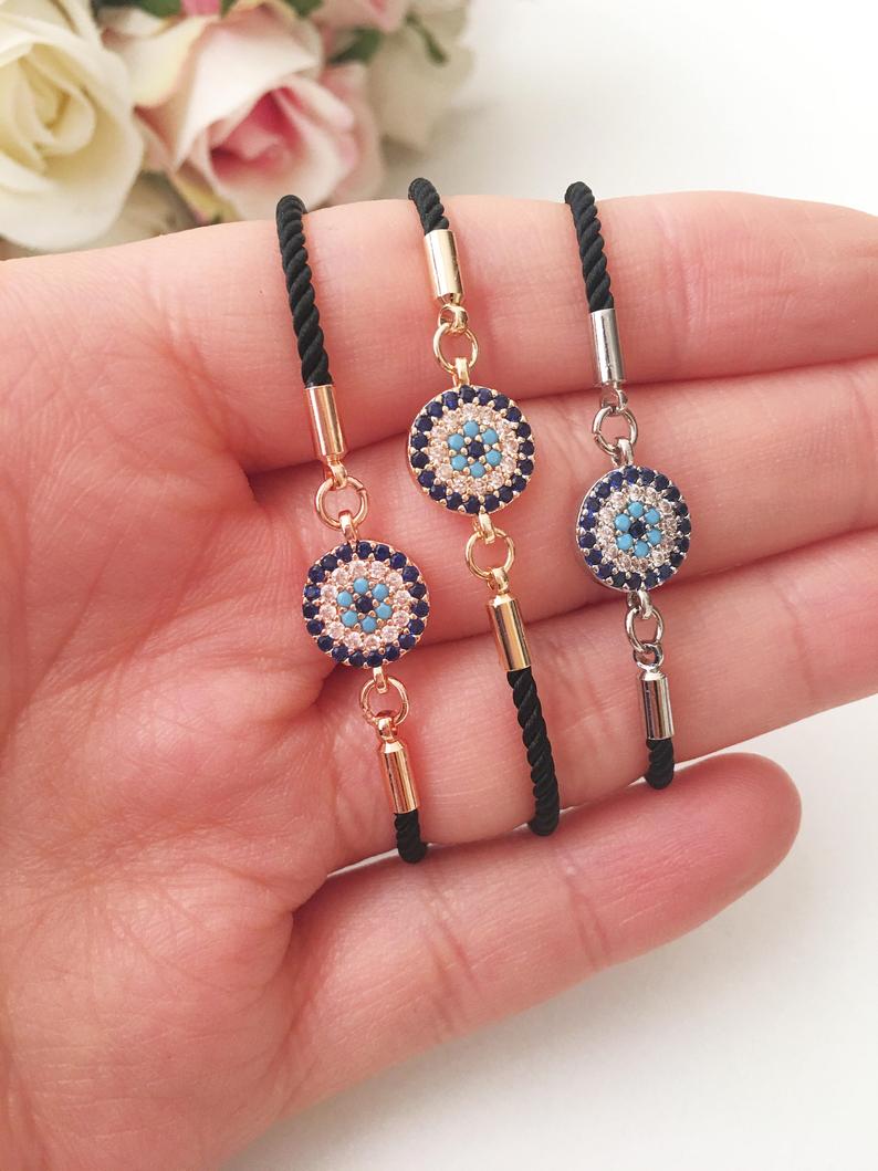 A stylish Evil Eye Bracelet featuring a beaded design with an adjustable string, available in silver and rose gold, made from tarnish-resistant stainless steel.