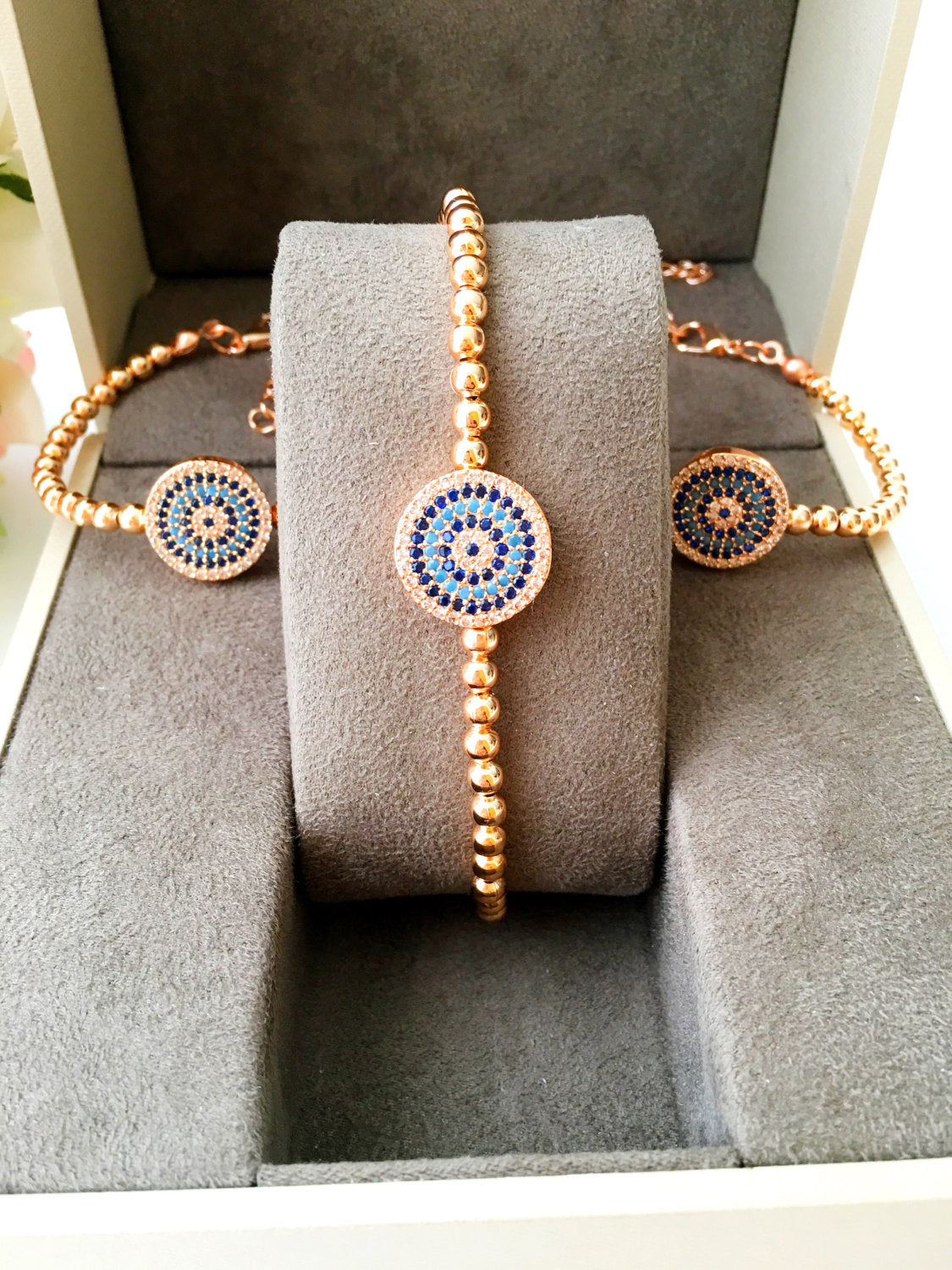 A beautiful Evil Eye Bracelet featuring adjustable beaded chain design in silver, gold, and rose gold finishes, adorned with zirconia accents.