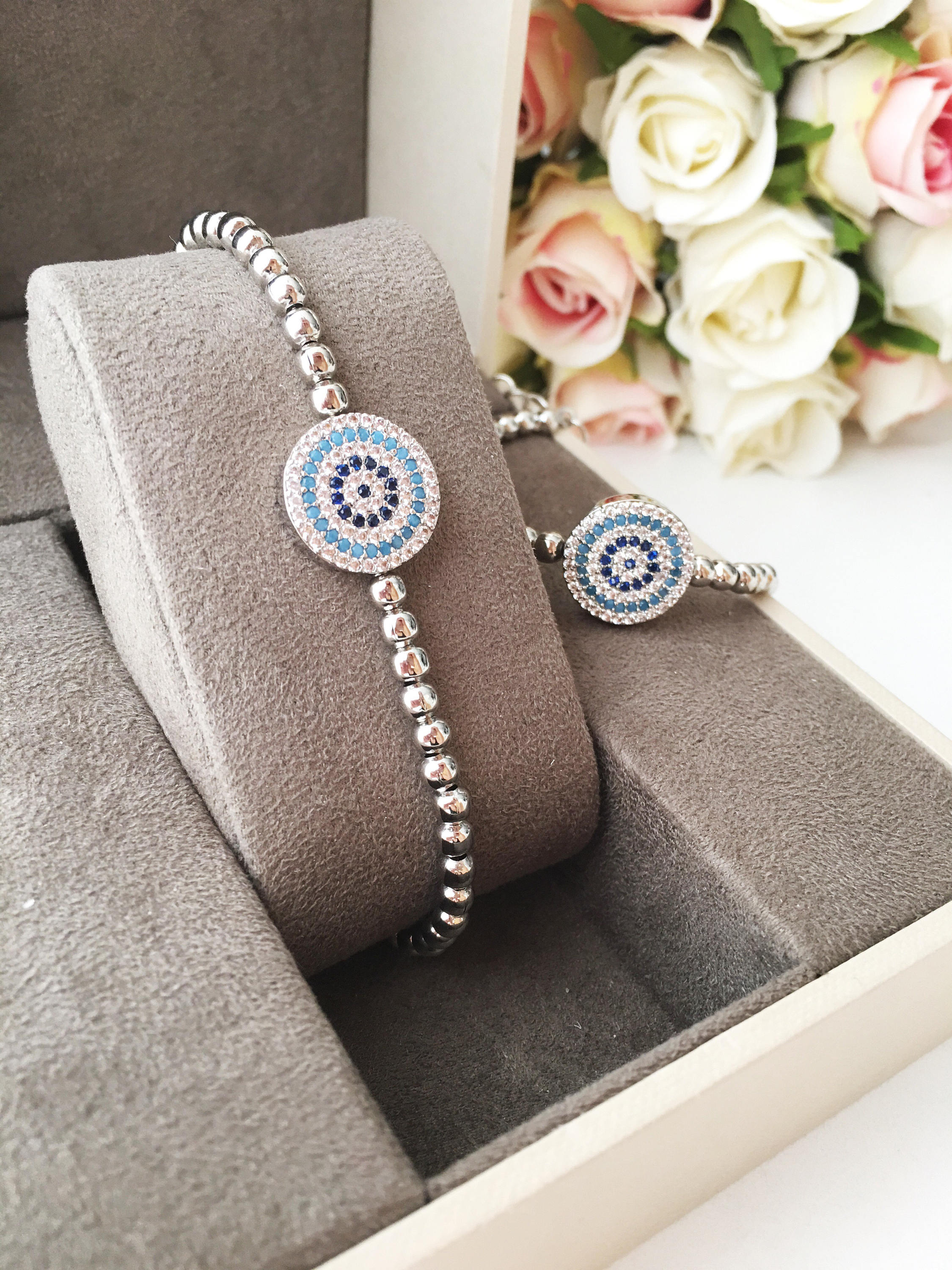 A beautiful Evil Eye Bracelet featuring adjustable beaded chain design in silver, gold, and rose gold finishes, adorned with zirconia accents.