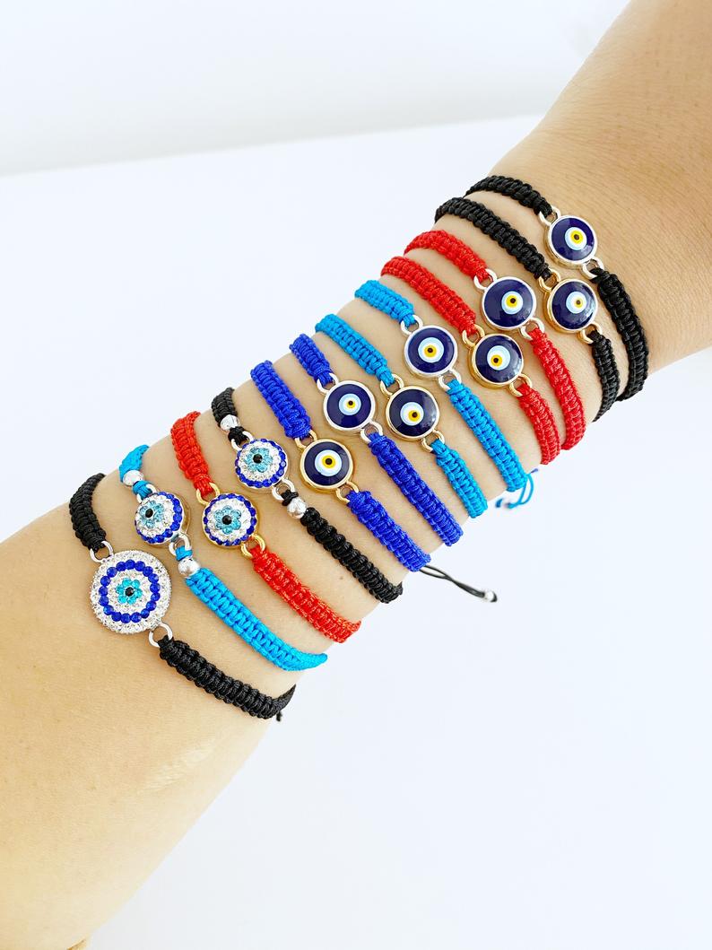 Handmade Evil Eye Bracelet featuring a central evil eye symbol on an adjustable black macramé band, available in 21 unique styles.