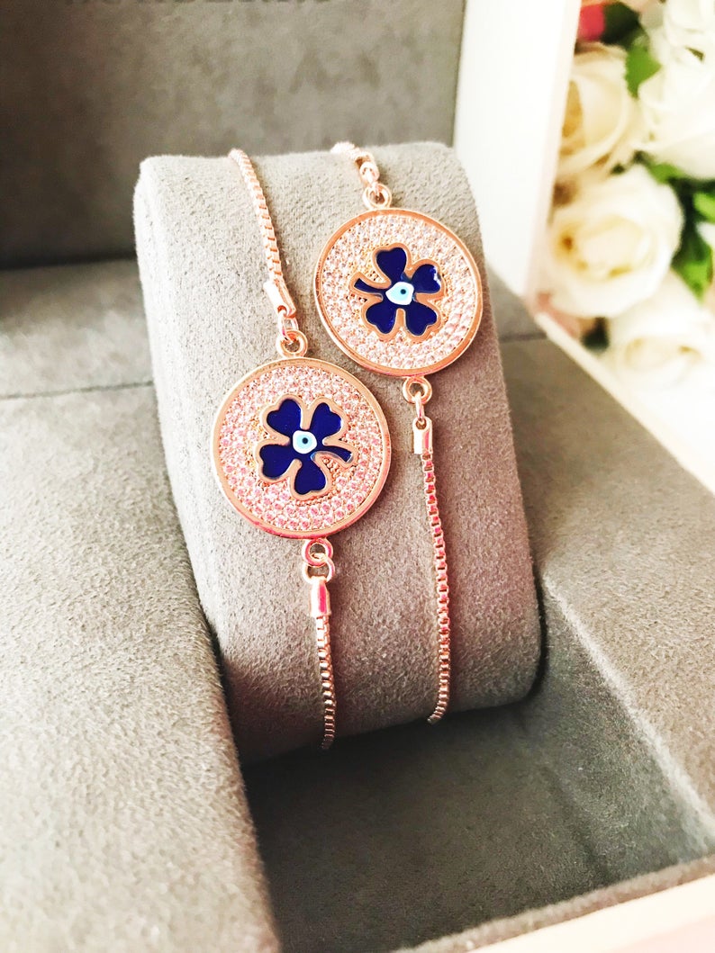 Handmade Evil Eye Bracelet featuring a blue evil eye charm and four leaf clover disc, elegantly designed with rose gold plating.