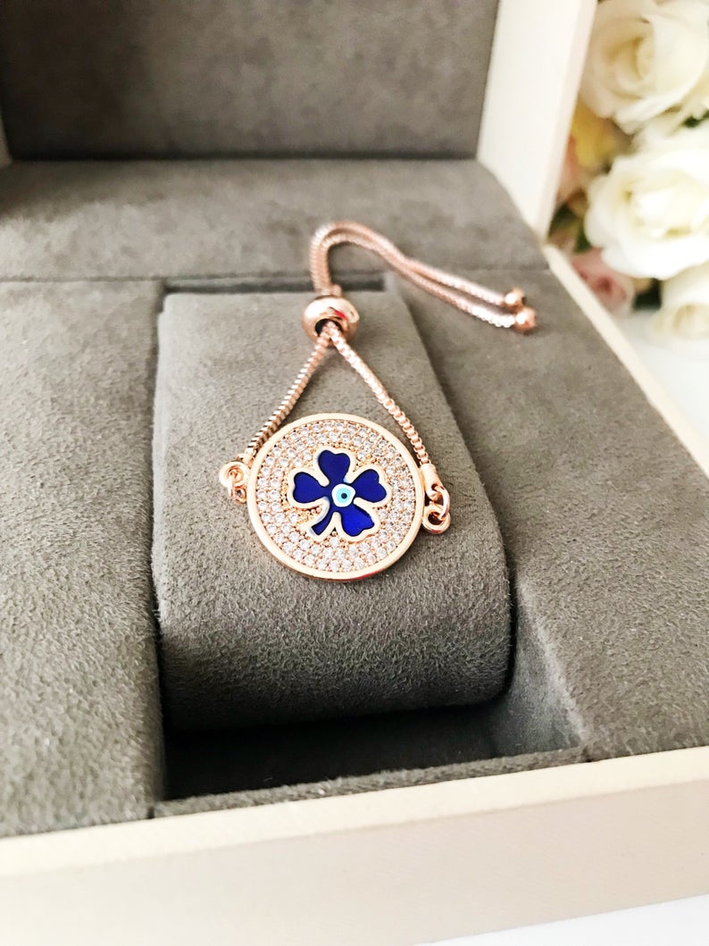 Handmade Evil Eye Bracelet featuring a blue evil eye charm and four leaf clover disc, elegantly designed with rose gold plating.