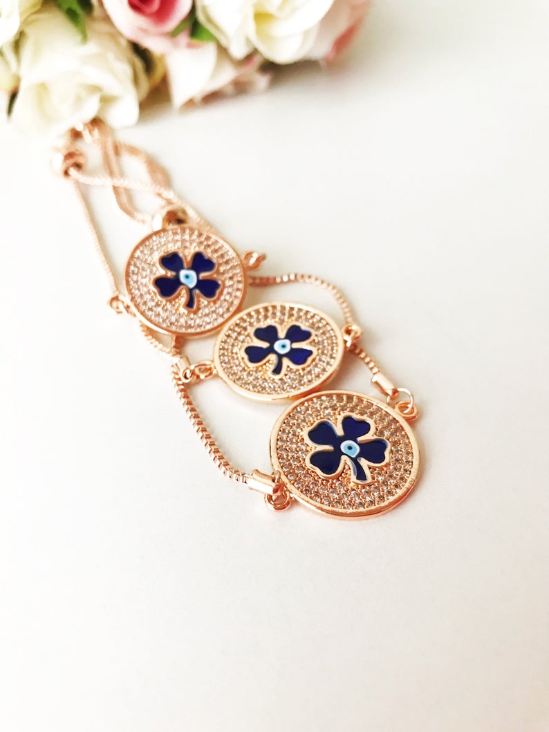 Handmade Evil Eye Bracelet featuring a blue evil eye charm and four leaf clover disc, elegantly designed with rose gold plating.