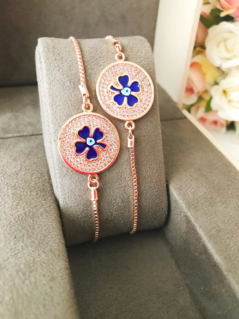 Handmade Evil Eye Bracelet featuring a blue evil eye charm and four leaf clover disc, elegantly designed with rose gold plating.