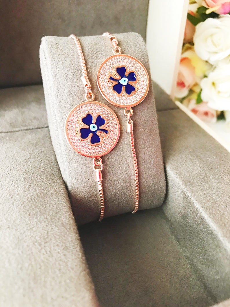 Handmade Evil Eye Bracelet featuring a blue evil eye charm and four leaf clover disc, elegantly designed with rose gold plating.