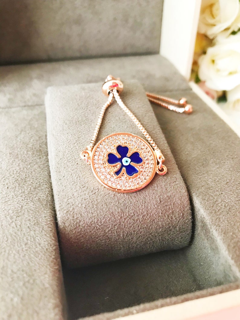 Handmade Evil Eye Bracelet featuring a blue evil eye charm and four leaf clover disc, elegantly designed with rose gold plating.