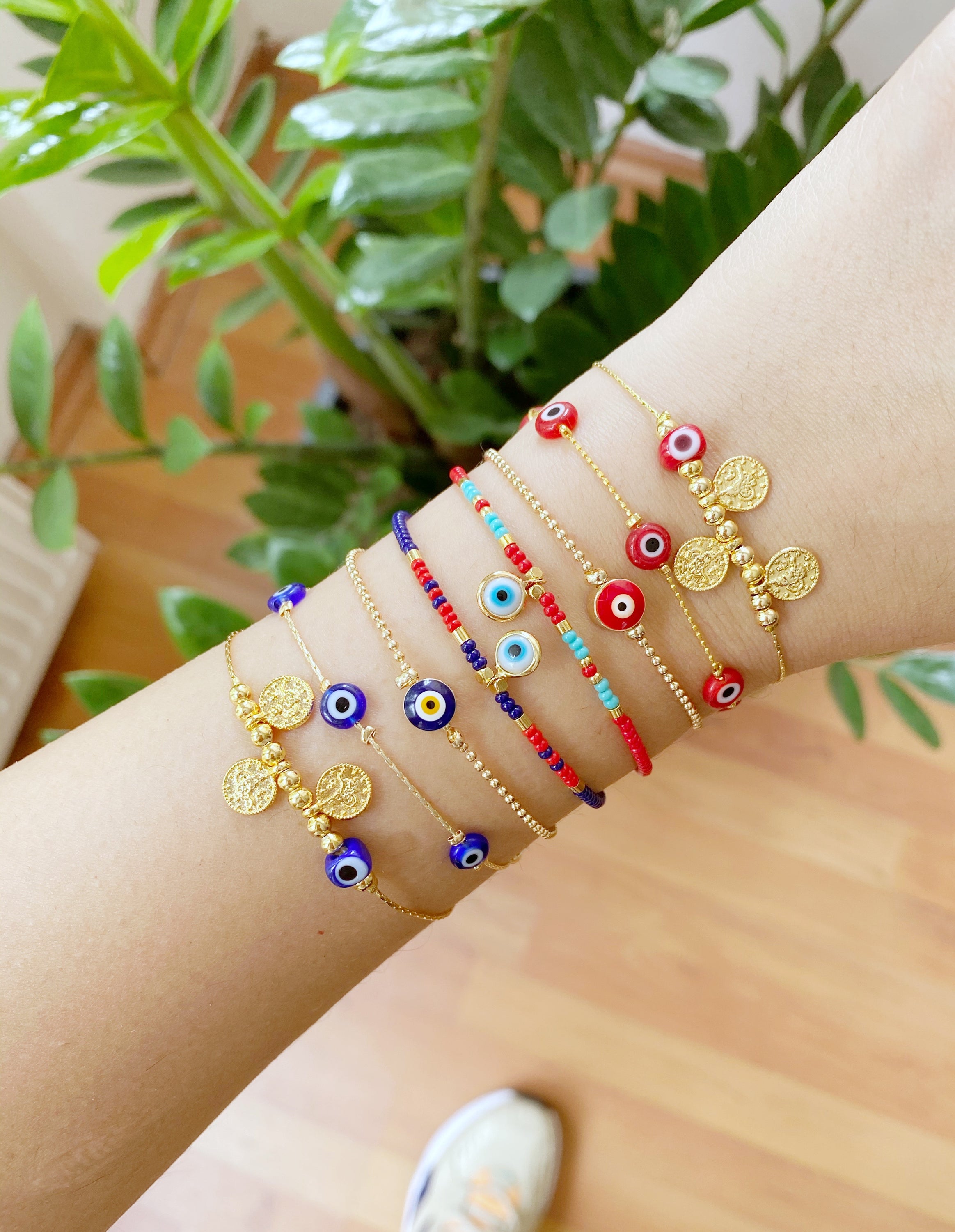 Handmade Evil Eye Bracelet featuring a gold chain with blue and red evil eye beads, symbolizing protection and luck.