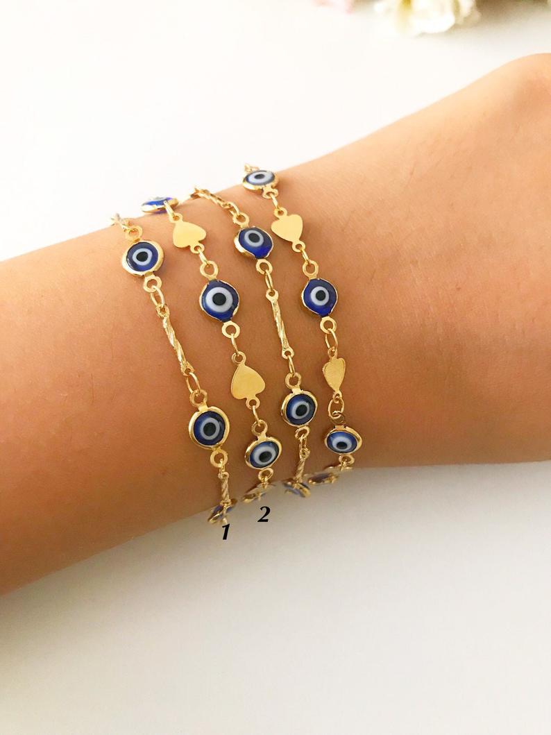 Elegant Evil Eye Bracelet featuring blue beads and a gold chain, symbolizing protection and good luck.