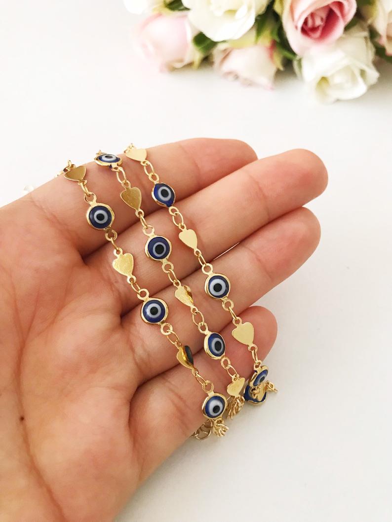 Elegant Evil Eye Bracelet featuring blue beads and a gold chain, symbolizing protection and good luck.