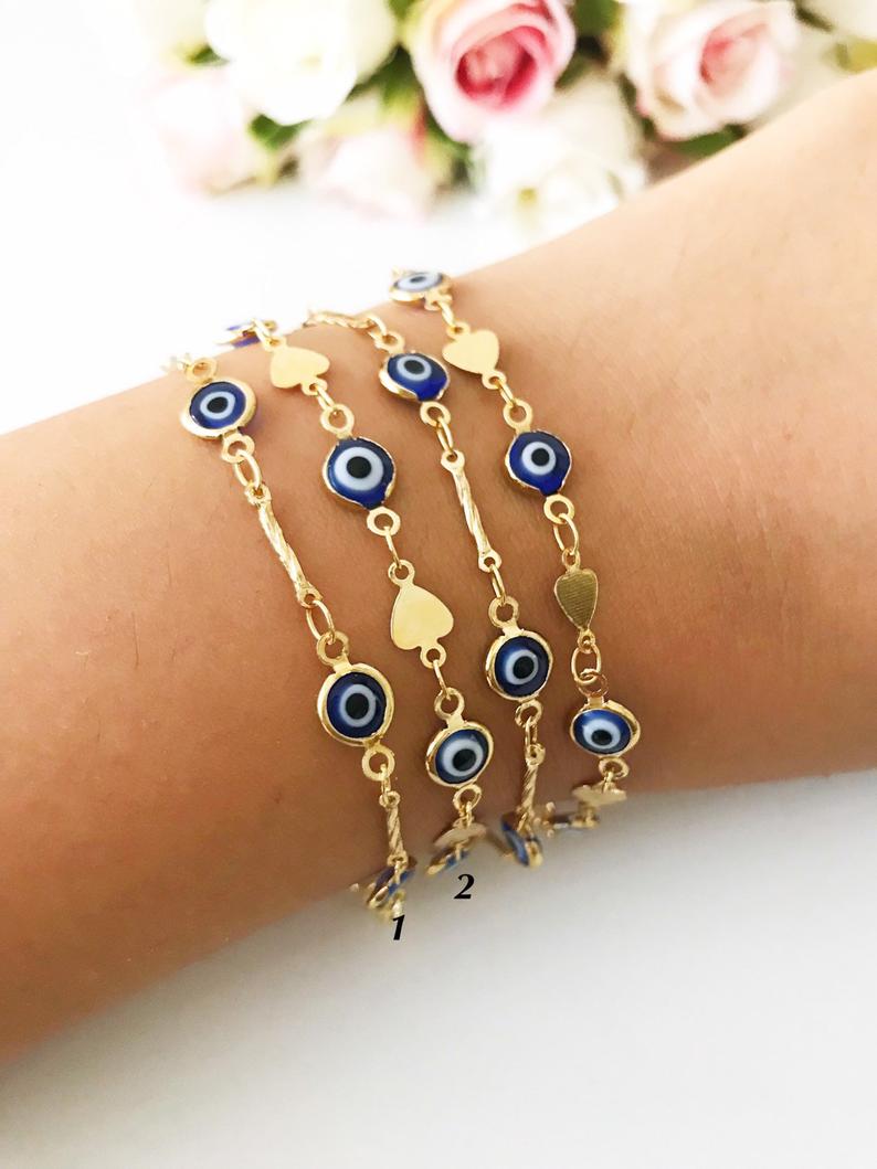 Elegant Evil Eye Bracelet featuring blue beads and a gold chain, symbolizing protection and good luck.