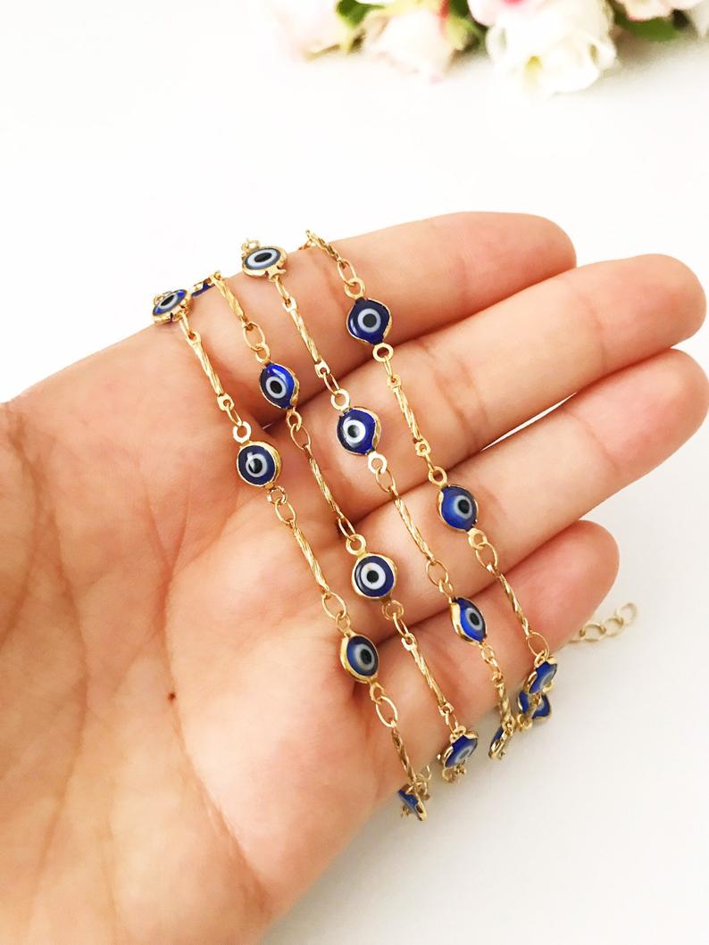 Elegant Evil Eye Bracelet featuring blue beads and a gold chain, symbolizing protection and good luck.