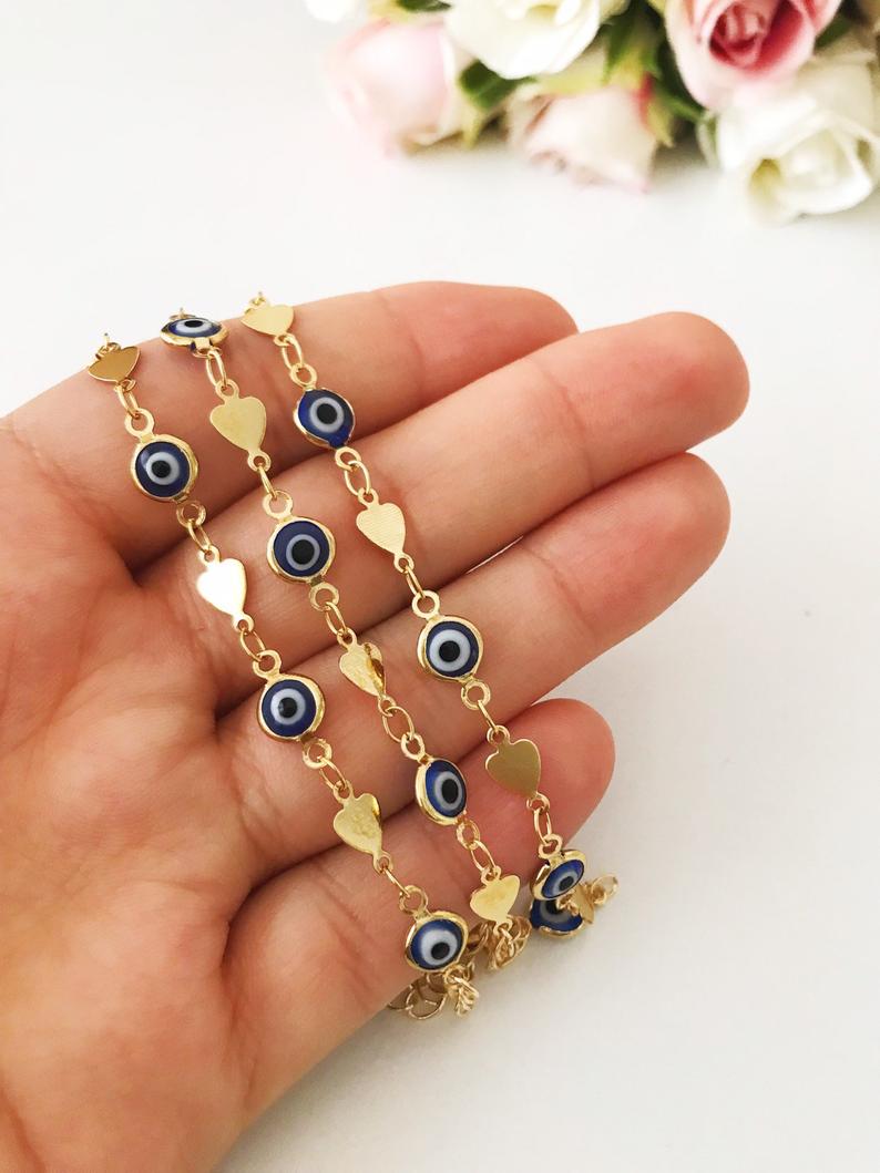 Elegant Evil Eye Bracelet featuring blue beads and a gold chain, symbolizing protection and good luck.