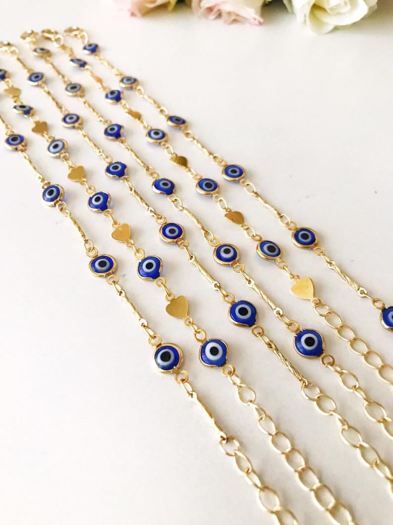 Elegant Evil Eye Bracelet featuring blue beads and a gold chain, symbolizing protection and good luck.