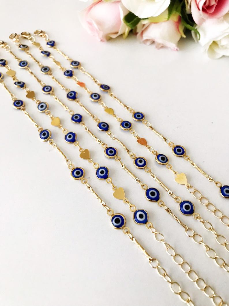 Elegant Evil Eye Bracelet featuring blue beads and a gold chain, symbolizing protection and good luck.