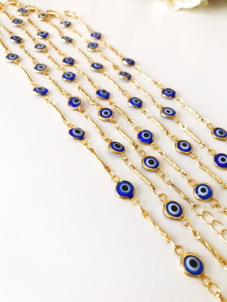 Elegant Evil Eye Bracelet featuring blue beads and a gold chain, symbolizing protection and good luck.