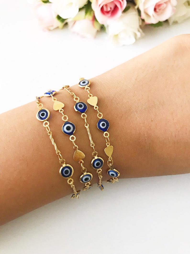 Elegant Evil Eye Bracelet featuring blue beads and a gold chain, symbolizing protection and good luck.