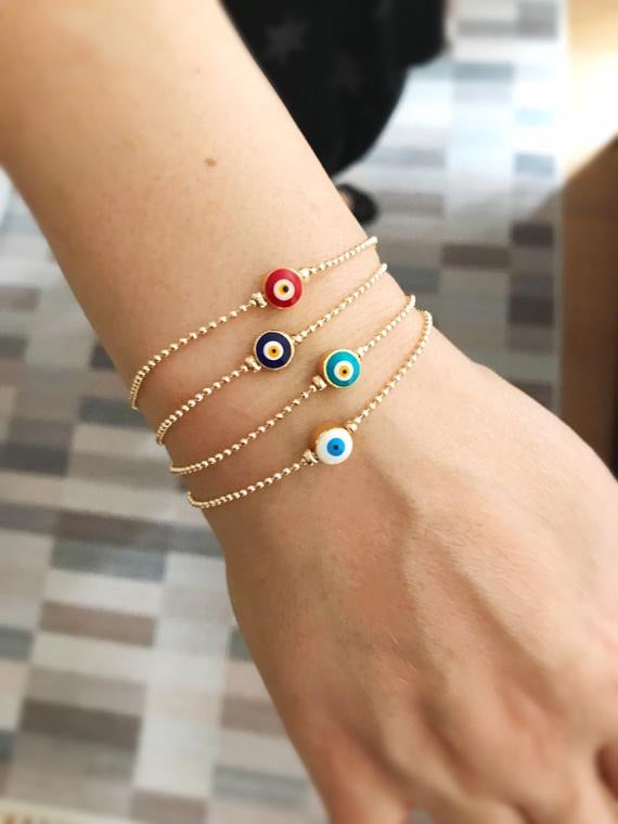 A beautiful gold evil eye bracelet featuring a blue evil eye bead, adjustable stainless steel chain, and available in four colors.