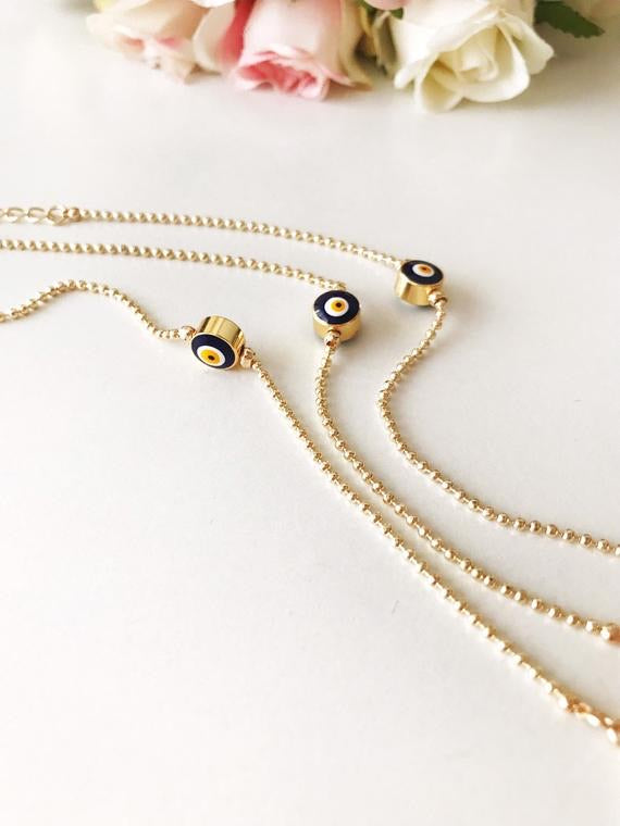 A beautiful gold evil eye bracelet featuring a blue evil eye bead, adjustable stainless steel chain, and available in four colors.