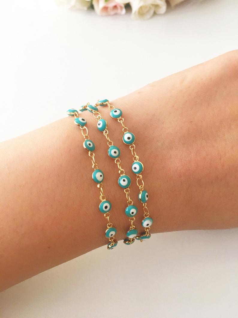 A minimalist evil eye bracelet featuring a gold link chain and turquoise glass beads, symbolizing protection and style.