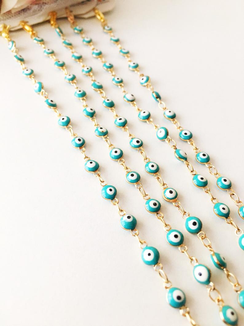 A minimalist evil eye bracelet featuring a gold link chain and turquoise glass beads, symbolizing protection and style.