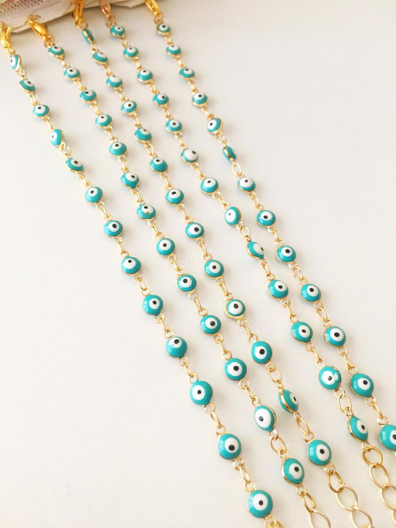 A minimalist evil eye bracelet featuring a gold link chain and turquoise glass beads, symbolizing protection and style.