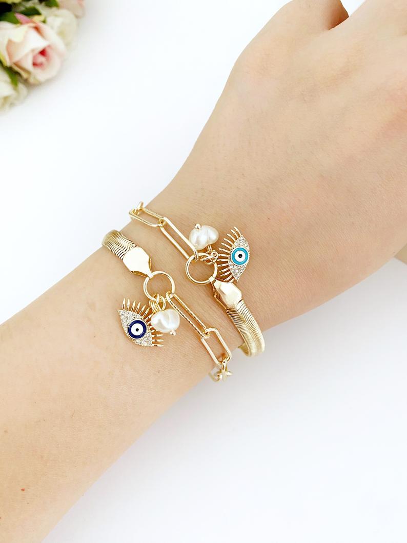 Elegant Evil Eye Bracelet featuring a gold oval link chain and a blue evil eye charm with a pearl accent.