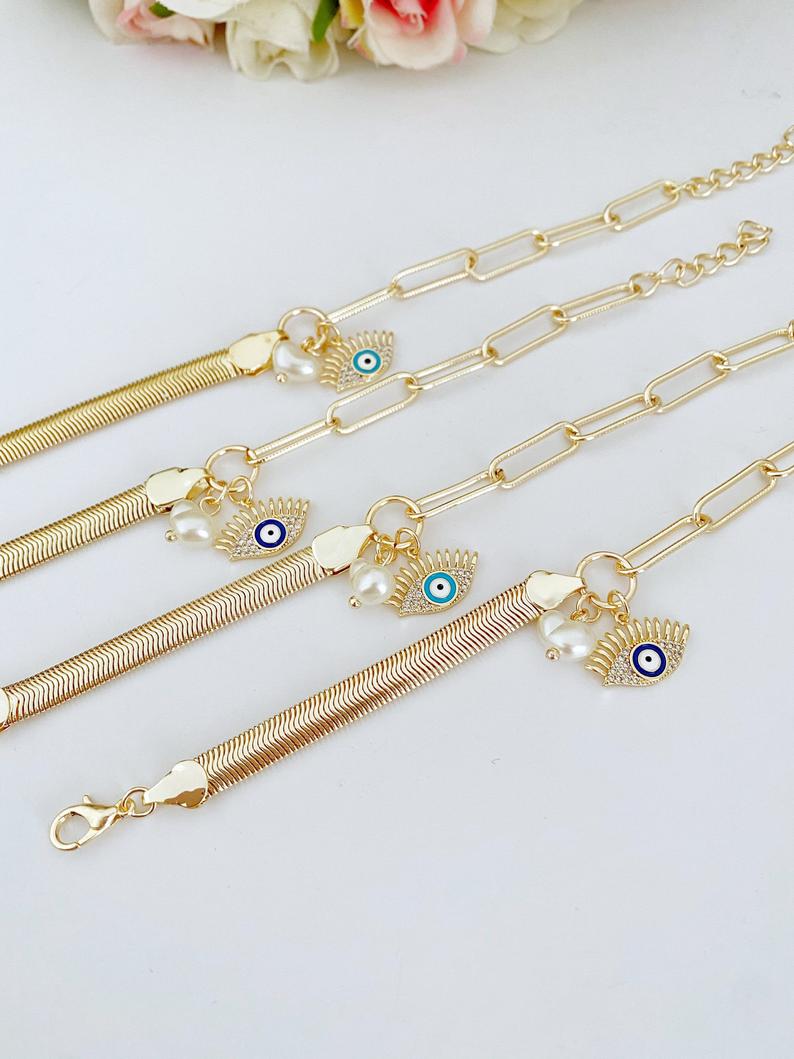 Elegant Evil Eye Bracelet featuring a gold oval link chain and a blue evil eye charm with a pearl accent.