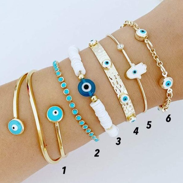 Gold wide bangle Evil Eye Bracelet with white heishi beads, showcasing a stylish and protective design.