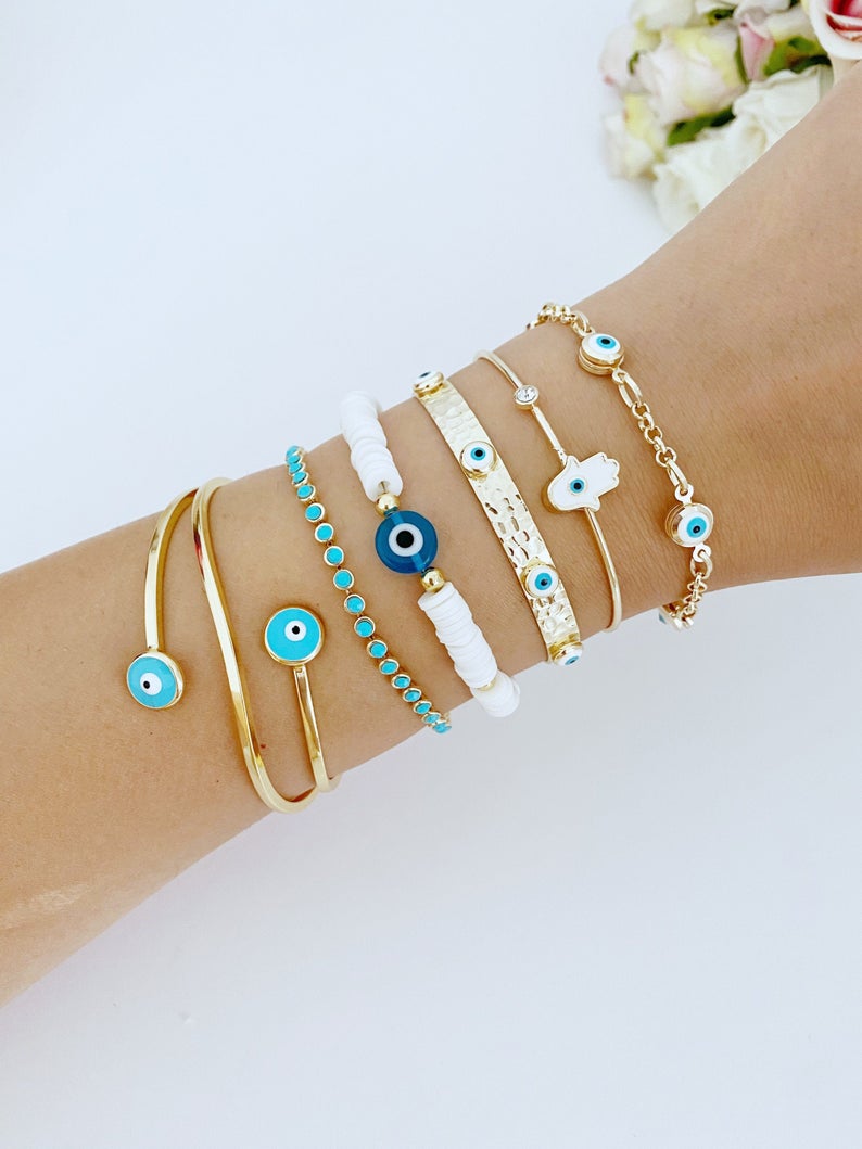 Gold wide bangle Evil Eye Bracelet with white heishi beads, showcasing a stylish and protective design.