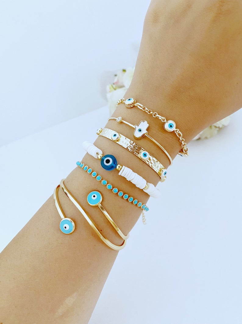 Gold wide bangle Evil Eye Bracelet with white heishi beads, showcasing a stylish and protective design.