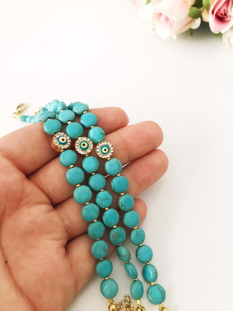 Handmade Evil Eye Bracelet featuring turquoise and white stone beads with an adjustable length and evil eye charm for protection.