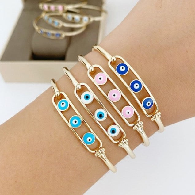 Elegant gold cuff Evil Eye Bracelet featuring a movable oval charm, available in four colors.