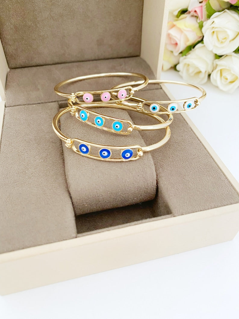 Elegant gold cuff Evil Eye Bracelet featuring a movable oval charm, available in four colors.