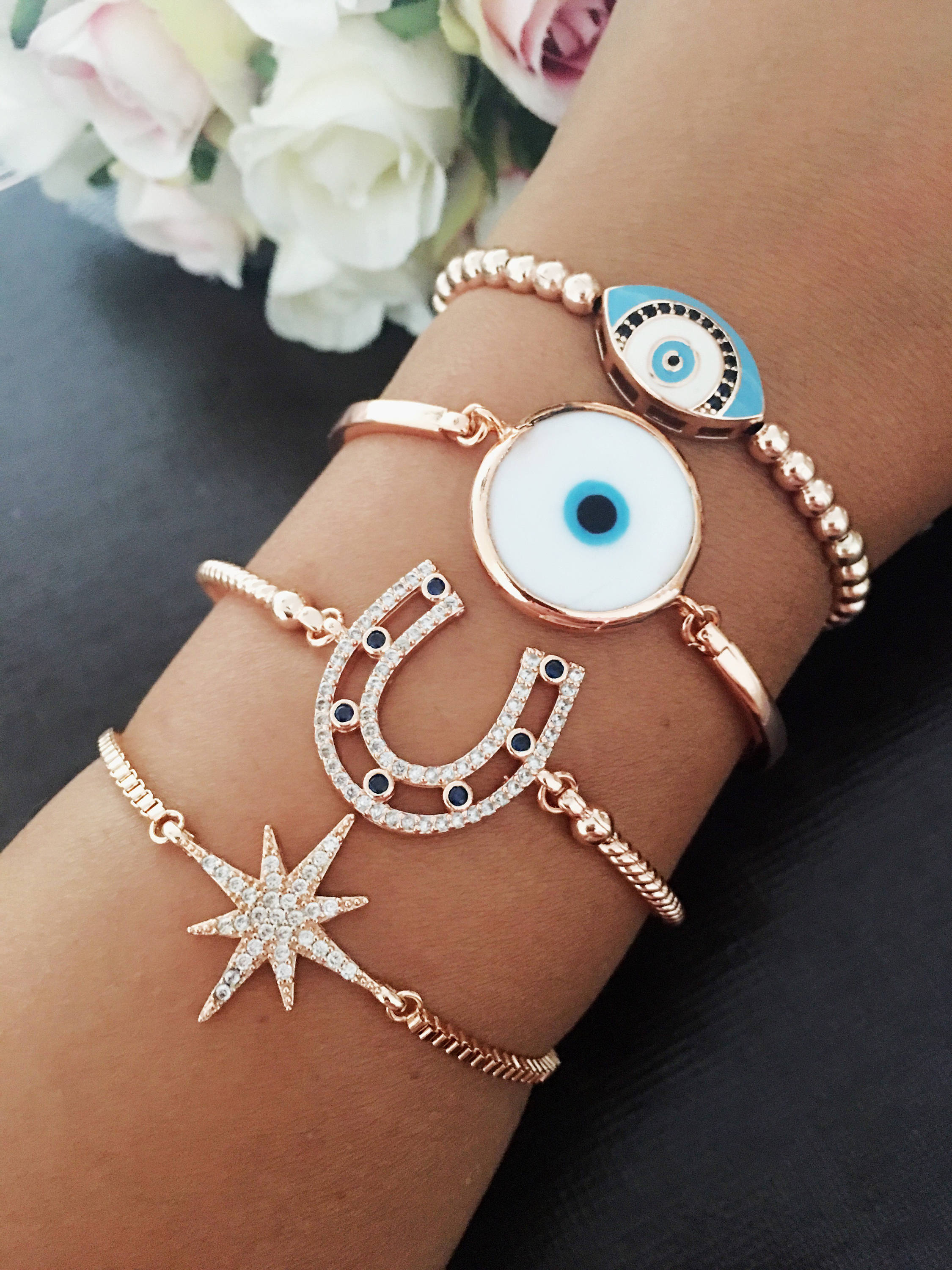 A collection of four unique Evil Eye Bracelets featuring star, horseshoe, Murano glass, and oval beaded designs, showcasing their elegant craftsmanship.