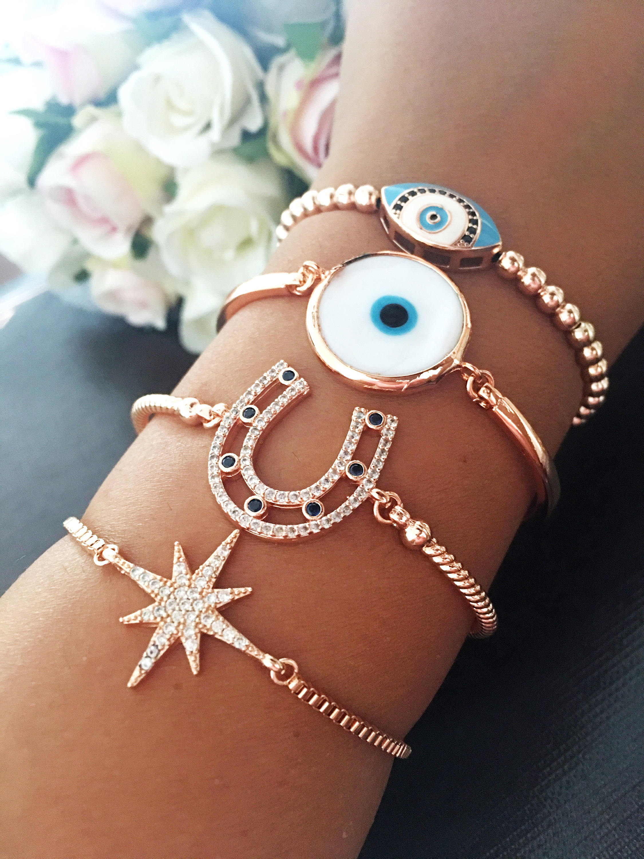 A collection of four unique Evil Eye Bracelets featuring star, horseshoe, Murano glass, and oval beaded designs, showcasing their elegant craftsmanship.