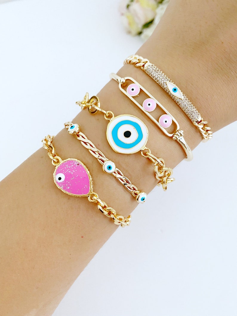 A beautiful pink and gold Evil Eye Bracelet featuring a movable oval charm, crafted from tarnish-resistant stainless steel, perfect for gifting.