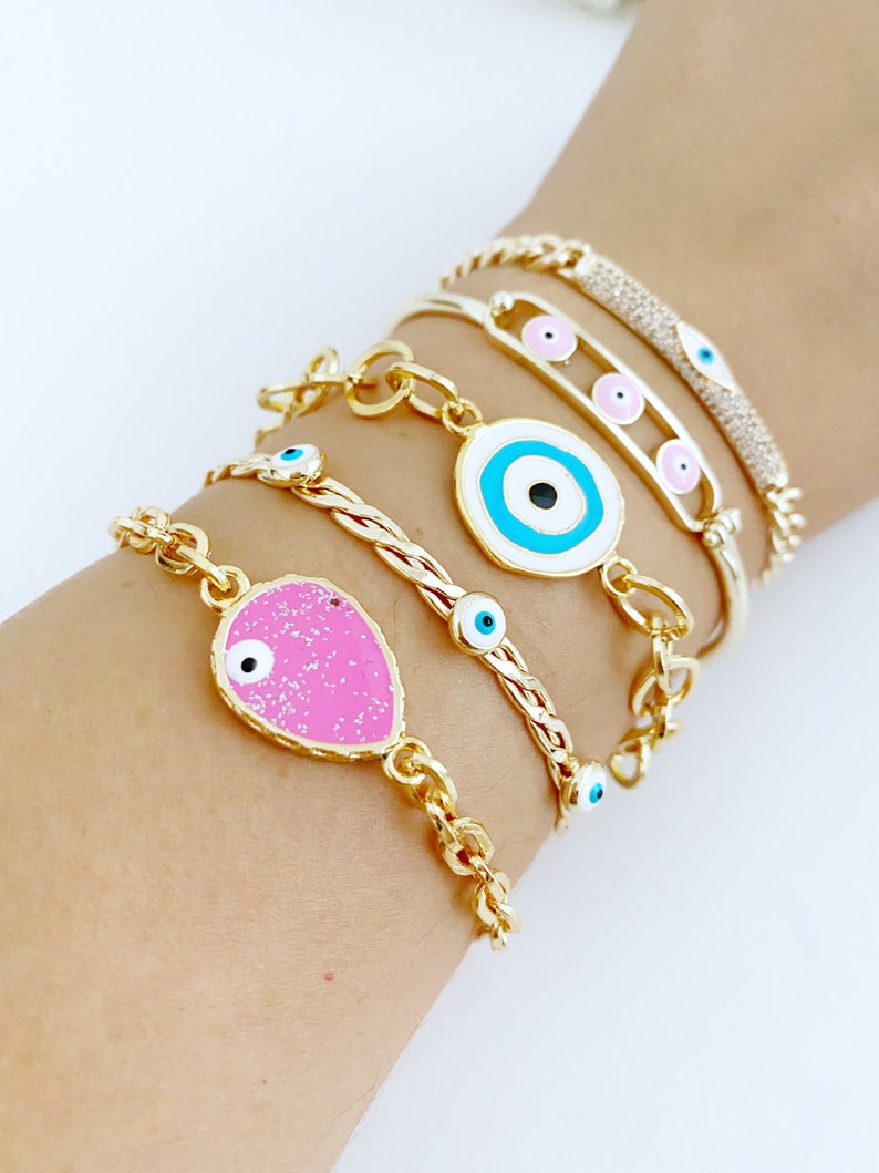 A beautiful pink and gold Evil Eye Bracelet featuring a movable oval charm, crafted from tarnish-resistant stainless steel, perfect for gifting.